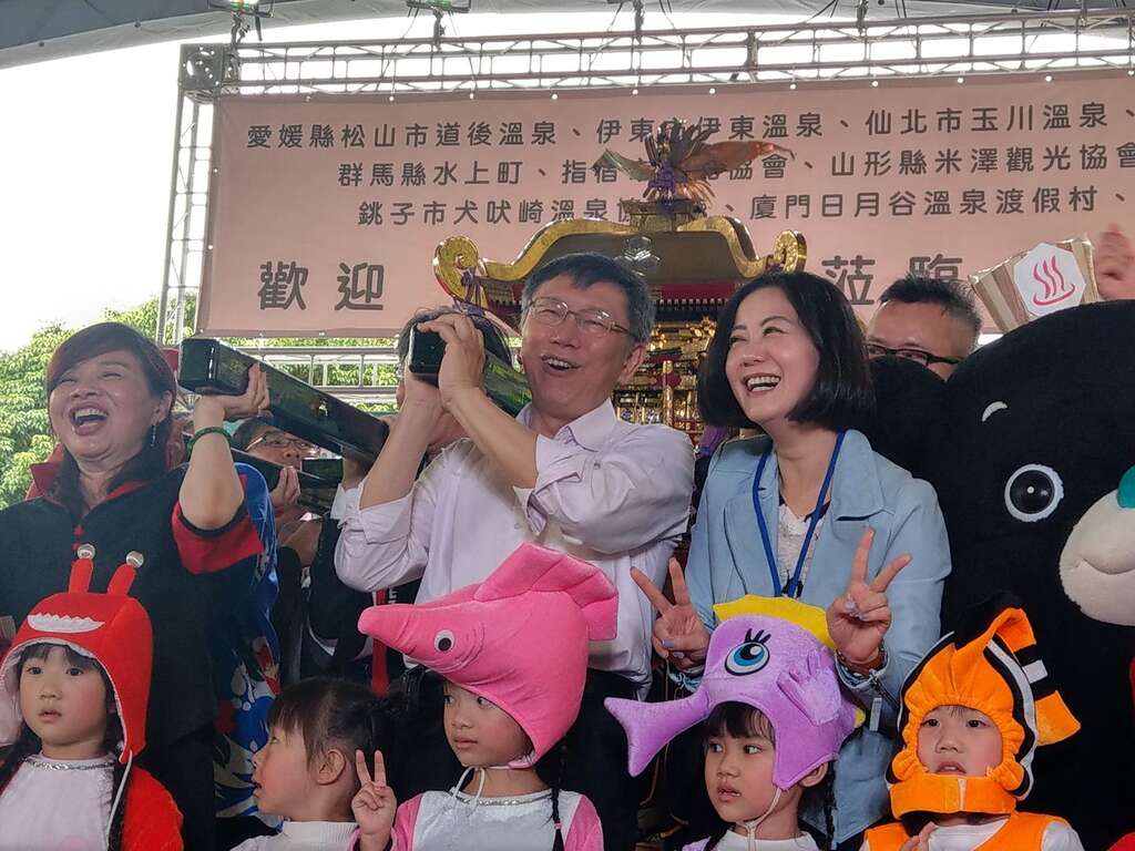 柯文哲市长(中)及台北市温泉发展协会周水美理事长(左)等贵宾一起抬神轿预祝温泉季顺利圆满成功