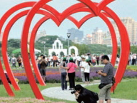 紅色心型拱門搭配繽紛花海，是遊客拍照的熱門景點。（郭鳳孝攝）