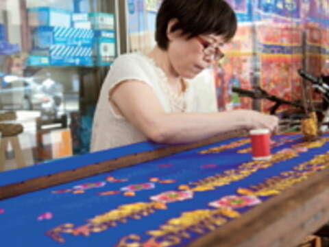 低頭密密縫的吳淑美，專心反覆刺上千百針，才能製出完美繡品。（顏涵正攝）