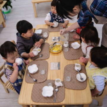 南港托嬰中心環境舒適，小朋友坐在一起吃點心，好不開心。（廖碩文攝）