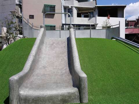兒童遊戲場地景山丘與親子同樂的寬版磨石子溜滑梯