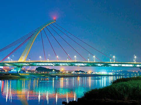 夜晚途經基隆河岸，可見大直橋燈光映照水面的美景。