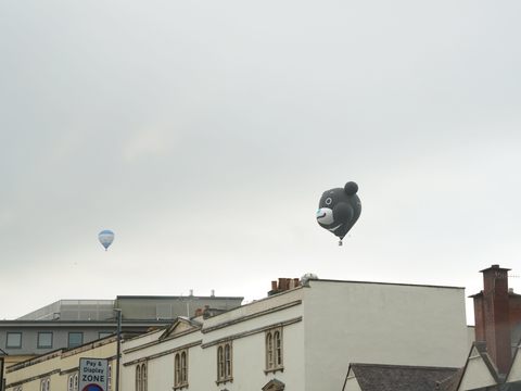 熊讚熱氣球飛翔於布里斯托城鎮上方，吸引當地民眾駐足觀看。(圖片來源：臺北市政府觀光傳播局)
