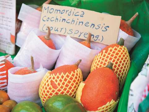 1-3蔬果攤老闆娘特意製作木鱉果的英文說明牌，讓外籍顧客也能一目了然。