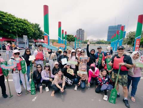 移工們個個開心的划完龍舟在岸上合影(圖片來源：臺北市政府勞動局)
