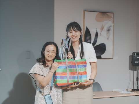 更新處黃美靜總工程司代表致贈「台味」禮物予遠道而來的分享者。(圖片來源：臺北市都市更新處更新經營科)