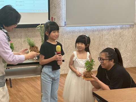 小朋友害羞地分享與家人一起完成的水苔球。