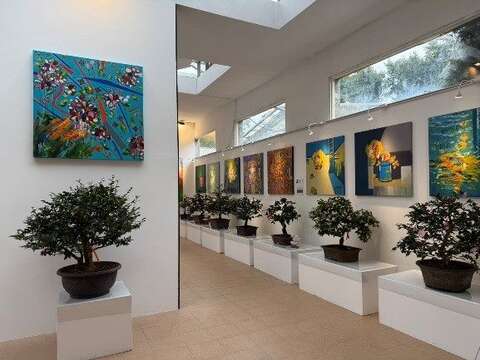 室內展場展示茶花盆景與藝術畫作，融合園藝與藝術之美（圖片來源：臺北市政府工務局公園路燈工程管理處）
