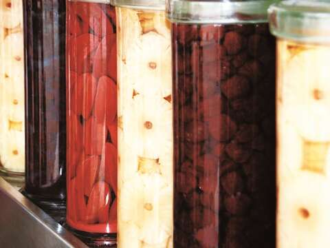成都楊桃冰店內整排的巨型玻璃罐，浸泡著各種醃漬水果。（攝影／焦桐）