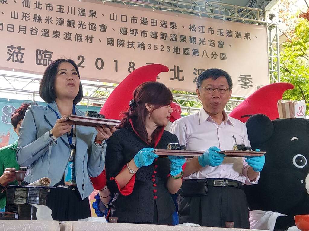柯市長(右)及臺北市溫泉發展協會周水美理事長(中)等貴賓一起手作海灣料理『北投捲』