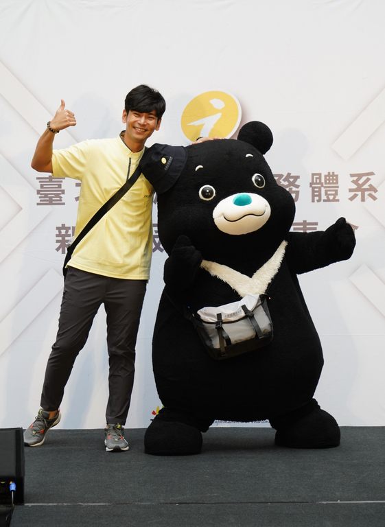 楊子儀與熊讚揹上側背包，扮演走動式旅遊服務人員