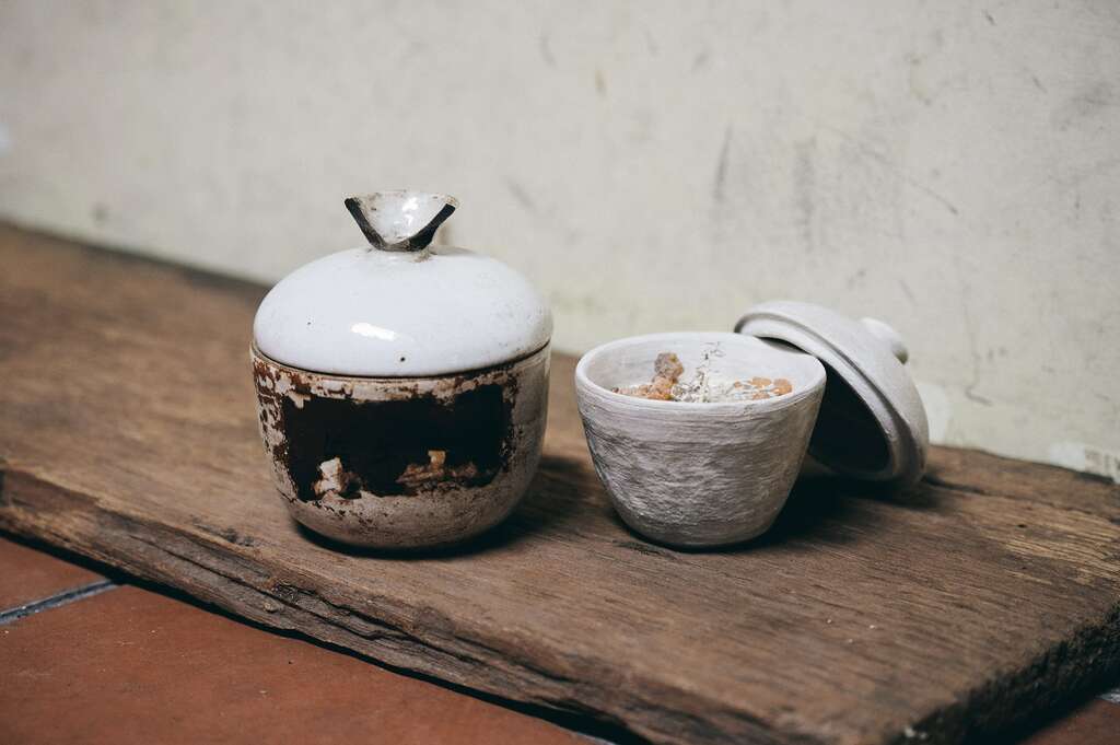 「地衣荒物」的热卖商品「中药陶罐蜡烛」（右），造型灵感来自传统中药罐（左）。（摄影／陈冠凯）