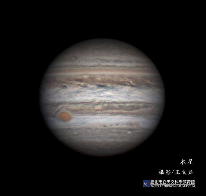 表面充滿斑斕帶紋的木星。左下角即著名的大紅斑，直徑可達數萬公里，為一類似颱風的巨大氣旋風暴。