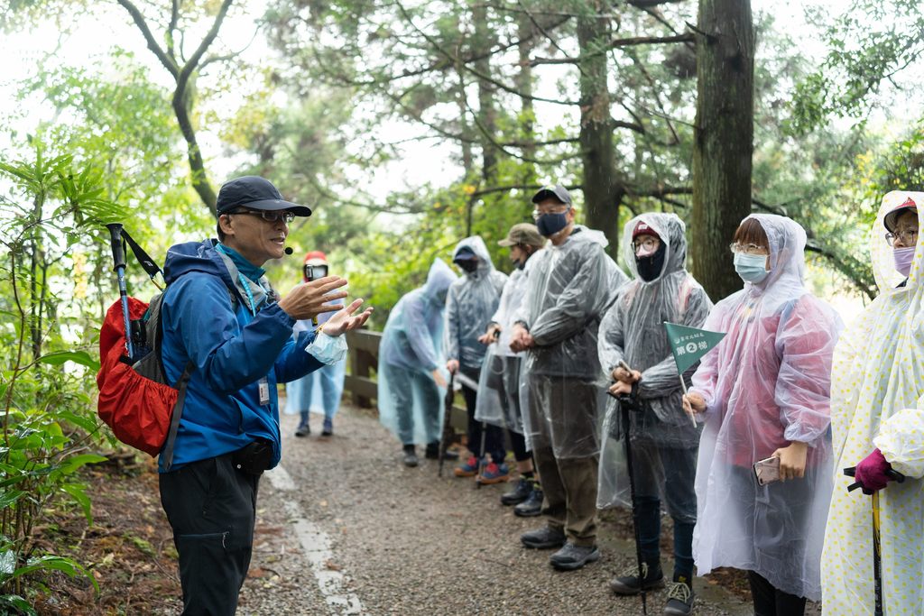 参与台北大纵走活动的民众专心聆听中华民国自然步道协会高老师介绍冷擎步道的植物
