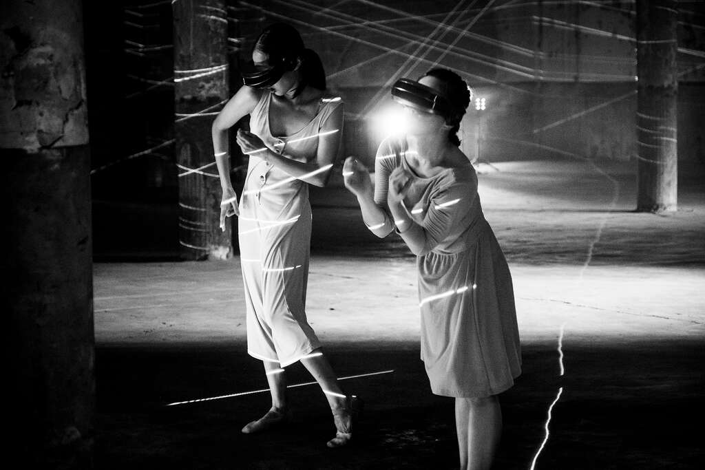 在《留給未來的殘影》中，舞者潘柏伶和方妤婷頭戴VR 頭戴顯示裝置，模擬觀眾觀看VR 影像的狀態，呈現使用者在強大包覆感中，全然沉浸在虛擬世界中的模樣。（圖／行者影像）