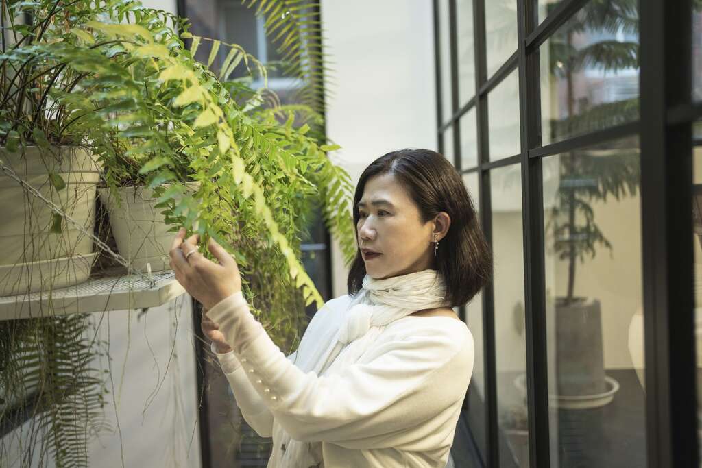 觀賞美麗的植物能讓彭樹君心情舒暢，激發書寫靈感。(攝影／陳志誠)