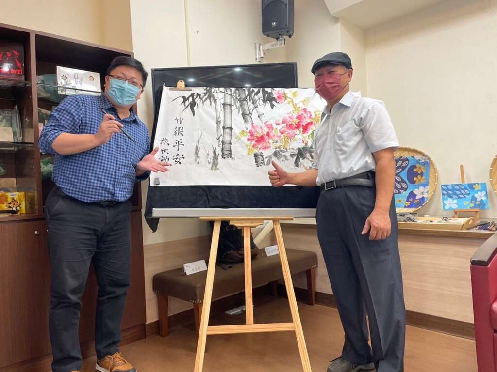 成果发表会开幕演出由北市客委会主委徐世勲在画作上题字寓意平安(图片来源：台北市政府客家事务委员会)