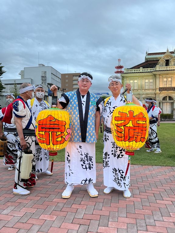 臺北市觀光傳播局劉奕霆局長(左)與弘前市櫻田宏市長(右)身著祭典服飾手持台北主題燈籠於遊行廣場前合影留念。