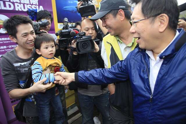 People fanatically flock around Taipei City Mayor Ko Wen-Je for a handshake