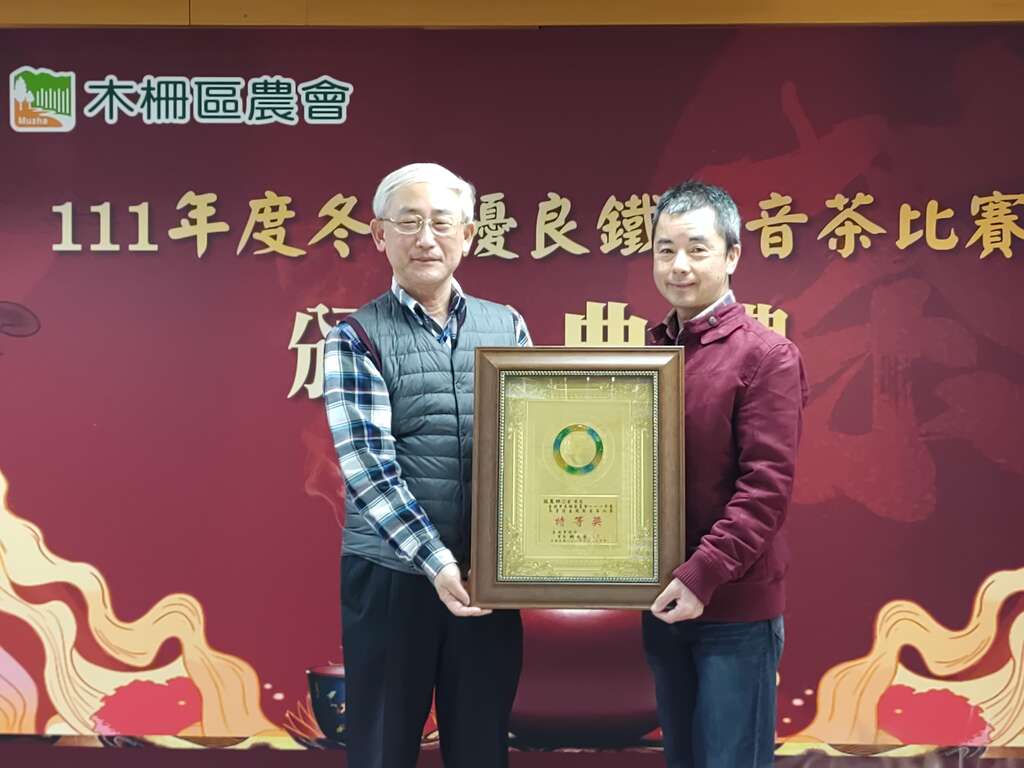 臺北市政府產業發展局王三中局長頒發市府獎牌予冬茶特等獎得主張農林(圖片來源：臺北市政府產業發展局)