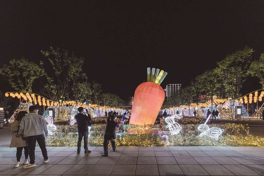 巨大的紅蘿蔔造型花燈，不只吸引可愛的白兔圍繞，也吸引民眾上前拍照，為中央展區增添活潑、趣味的氛圍。（攝影／林冠良）