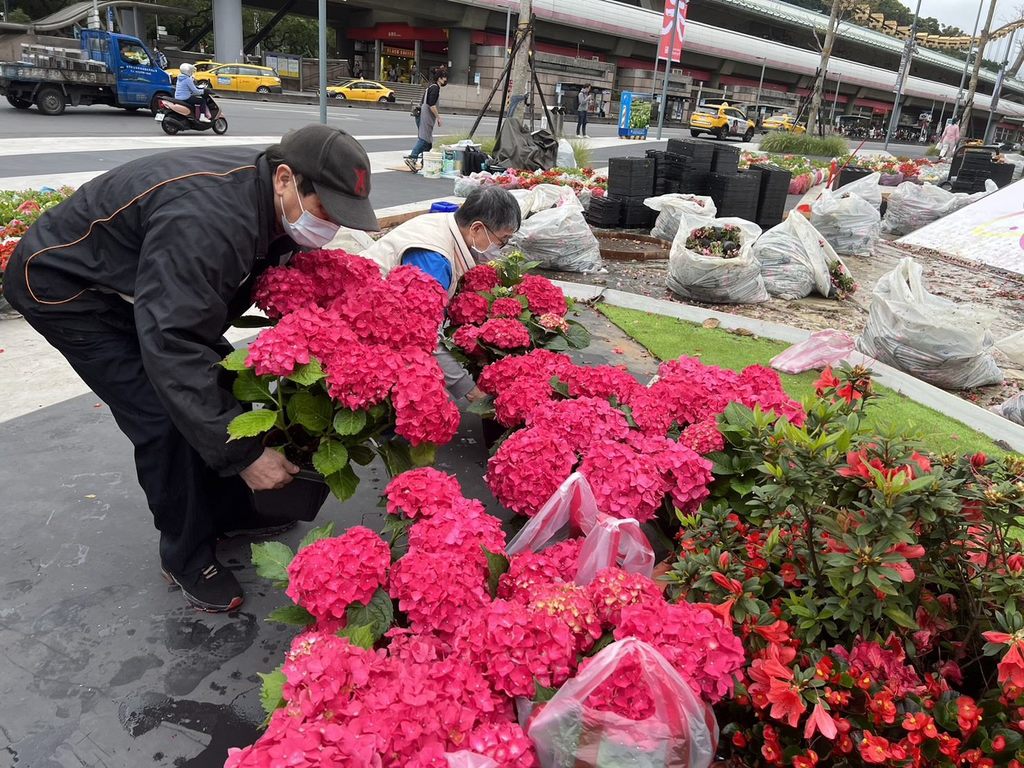 北艺中心周边在地里里长，带着里民一同领取盆花。(图片来源：台北市政府观光传播局)