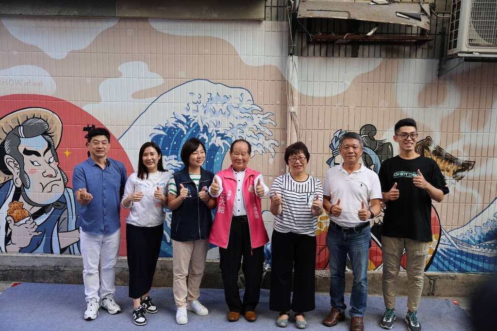 商業處江美玲副處長與創作者「開根號」於彩繪故事牆前合影(圖片來源：臺北市商業處)