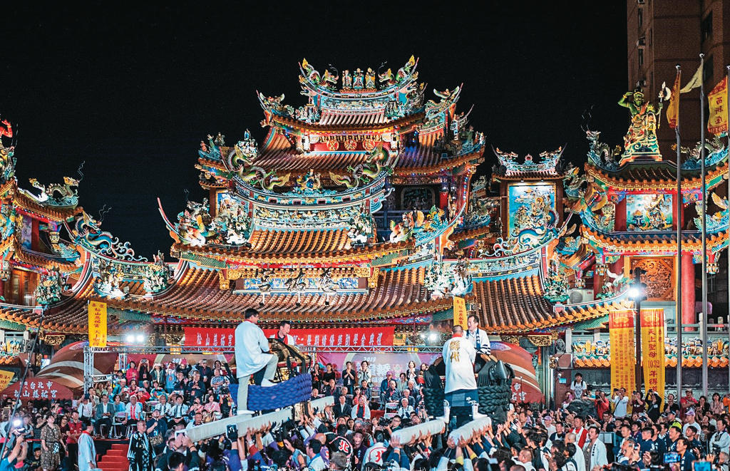 在松山慈佑宫前，上演日式撞神轿祈福活动，感受近百人扛起大神轿互相冲撞的壮观场面。