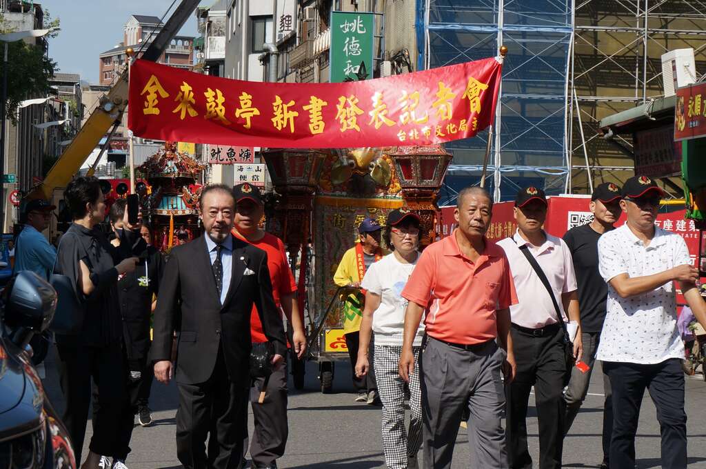 在台北共樂軒民藝文化協會理事長王崑文(圖右)及軒社元老頭人蔡金塗先生公子蔡桂良帶領下，共樂軒及金來鼓亭兩樂團子弟一起遶境宣傳新書發表(圖片來源：臺北市政府文化局)