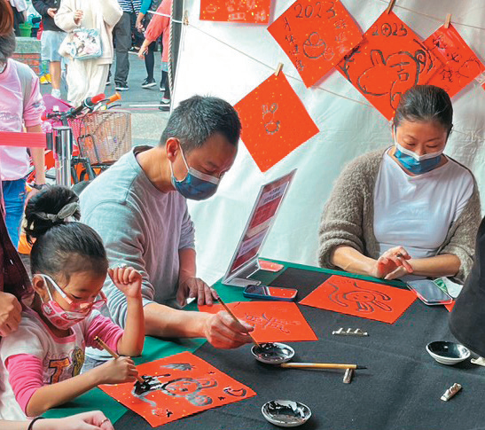 民众参与台北年货大街举办的斗方挥毫体验活动。