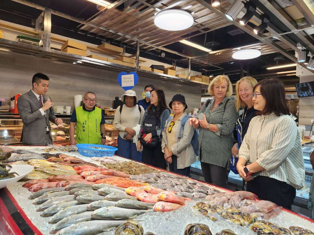 市府人員翻譯介紹特色攤位「盧記水產」(圖片來源：臺北市市場處)