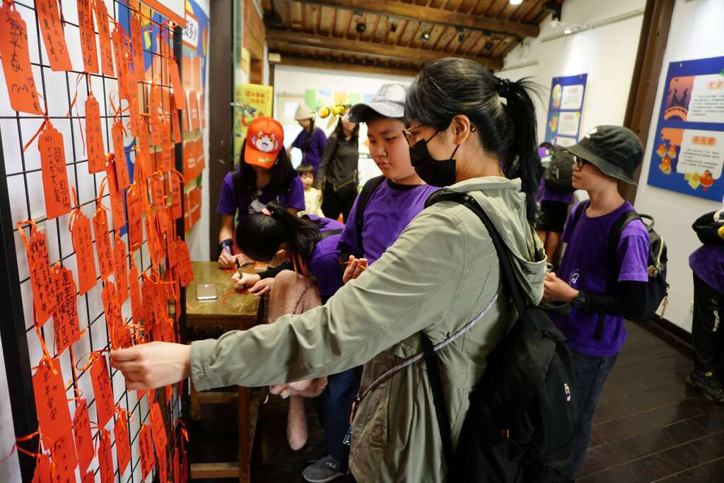 参观民众与学童写下新年的愿望挂上祈福墙(图片来源：台北市政府教育局)