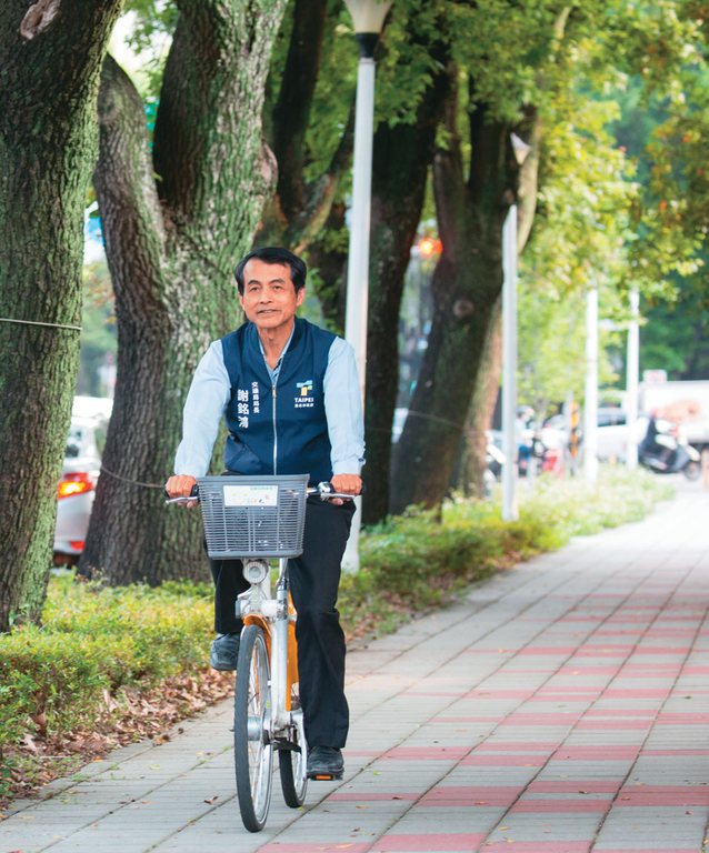 台北市交通局長謝銘鴻於「人車共道」的人行道騎乘自行車。（攝影／林煒凱）