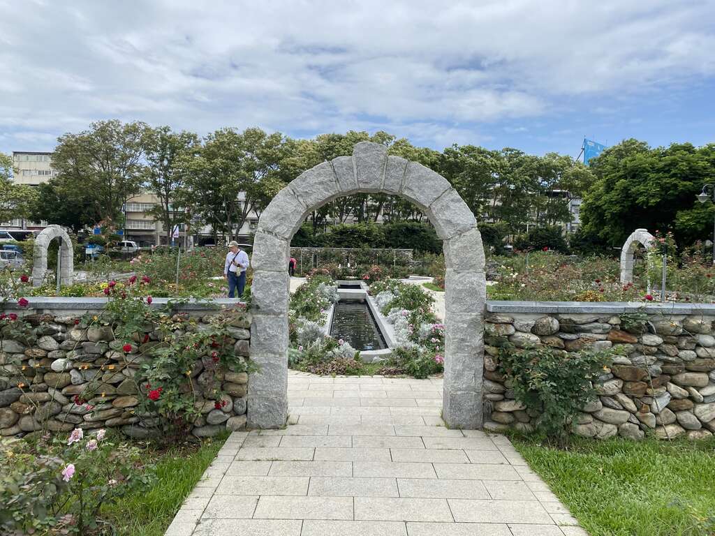從石頭拱門往秘密花園區取景，讓玫瑰、繽紛草花和光臘樹一同入鏡。(圖片來源：臺北市政府工務局公園路燈工程管理處)