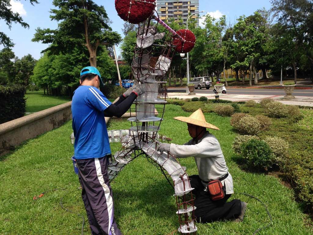 公園處員工在豔陽下為運動綠雕進行現場定位及固定工作。（圖／台北市工務局公園路燈工程管理處提供）