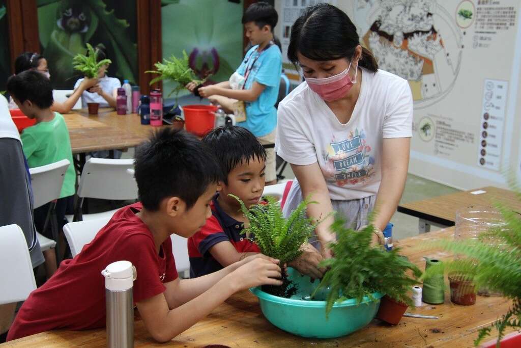 非常认真学习捏水苔球的方法。(图片来源：台北市政府工务局公园路灯工程管理处)