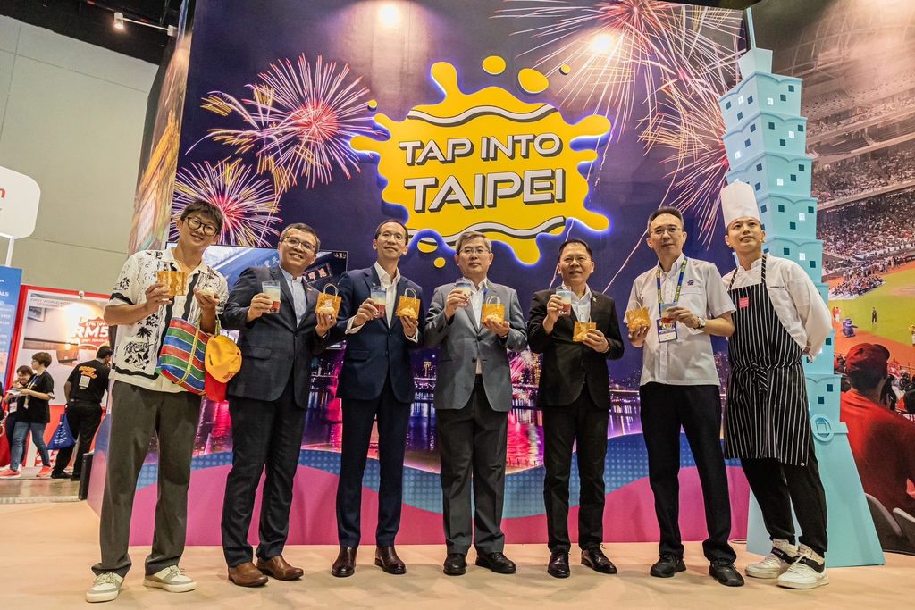 2024馬來西亞國際旅遊展(MATTA FAIR)臺北館開幕，臺北市祕書長李泰興(中)、觀傳局長王秋冬(右三)與馬來西亞旅遊總會總會長王振添(左三)、出境部副會長張耀權(右二)，以及吉隆坡辦事處主任周士弼一起體驗珍珠奶茶、玉兔造型香氛蠟燭。(圖片來源：臺北市政府觀光傳播局)