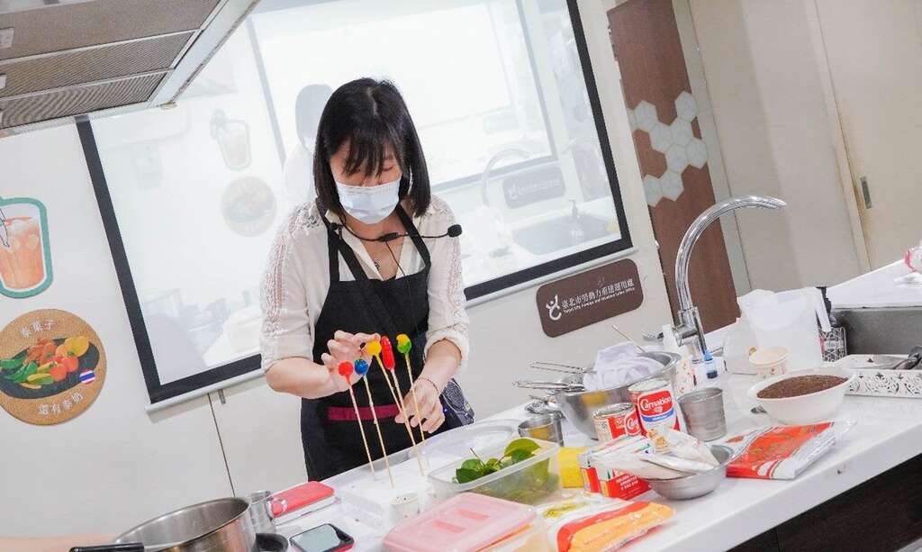 野餐市集摊位有多元东南亚美食，最道地的口味征服您的味蕾。(图为本处112年多元文化共融系列活动中泰国场料理课讲师「泰」菓子制作)(图片来源：台北市政府劳动局)
