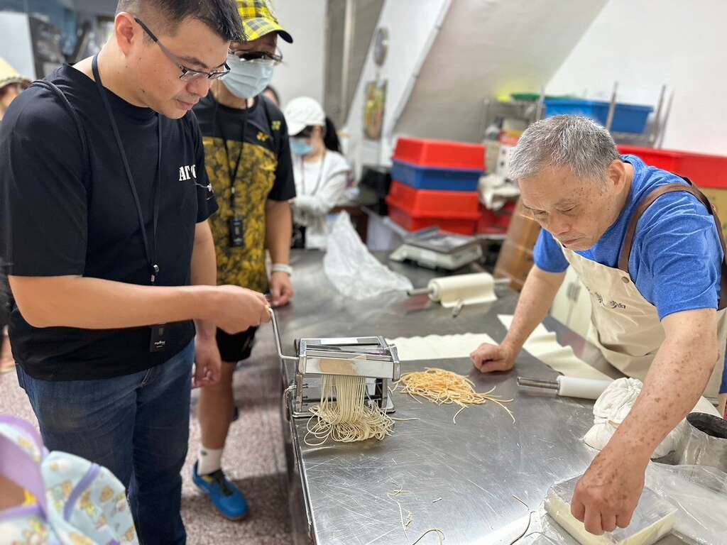 民眾於店家「菜漆麵匠」(永恆製麵店)體驗製麵機(圖片來源：臺北市商業處)