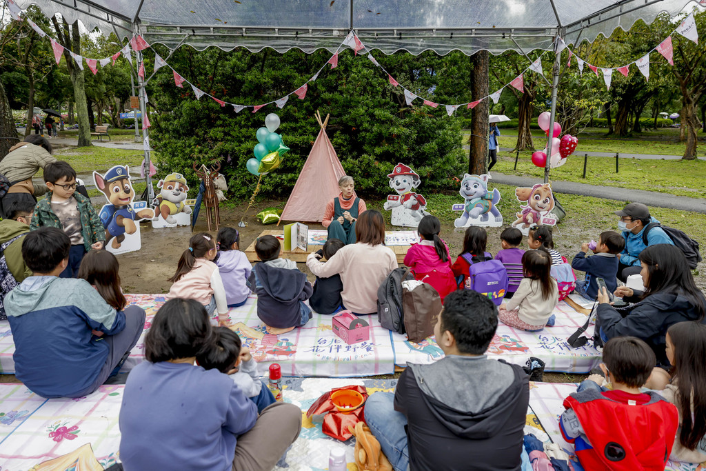 「大地繪閱」野餐區雙語說故事，小朋友專注聆聽(圖片來源：臺北市政府觀光傳播局)