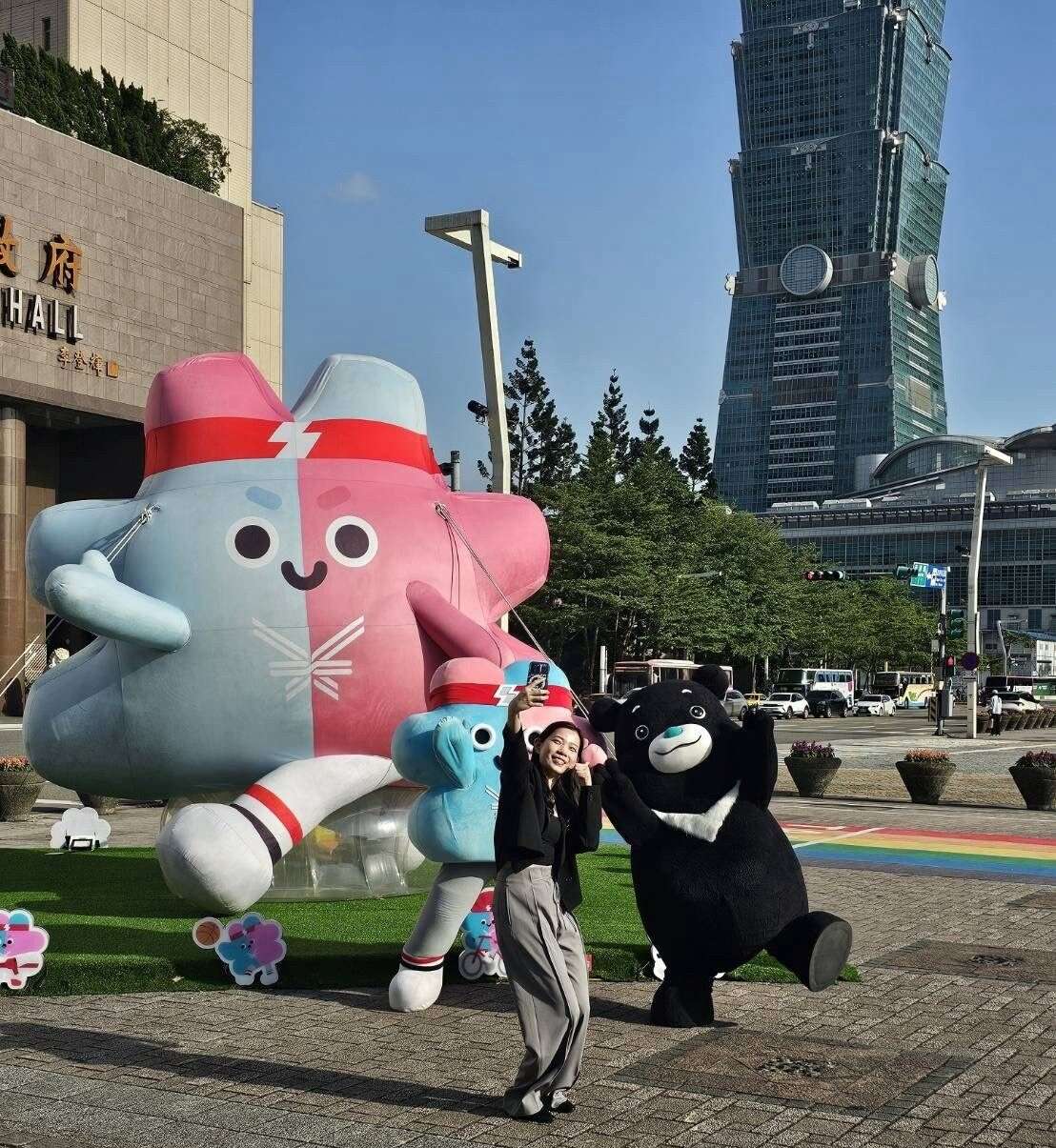 在台北市民广场前的「壮宝气偶」已成为台北市最热门打卡景点，观传局长余祥与吉祥物壮宝、熊赞一起合影宣传2025双北世壮运。(图片来源：台北市政府观光传播局)