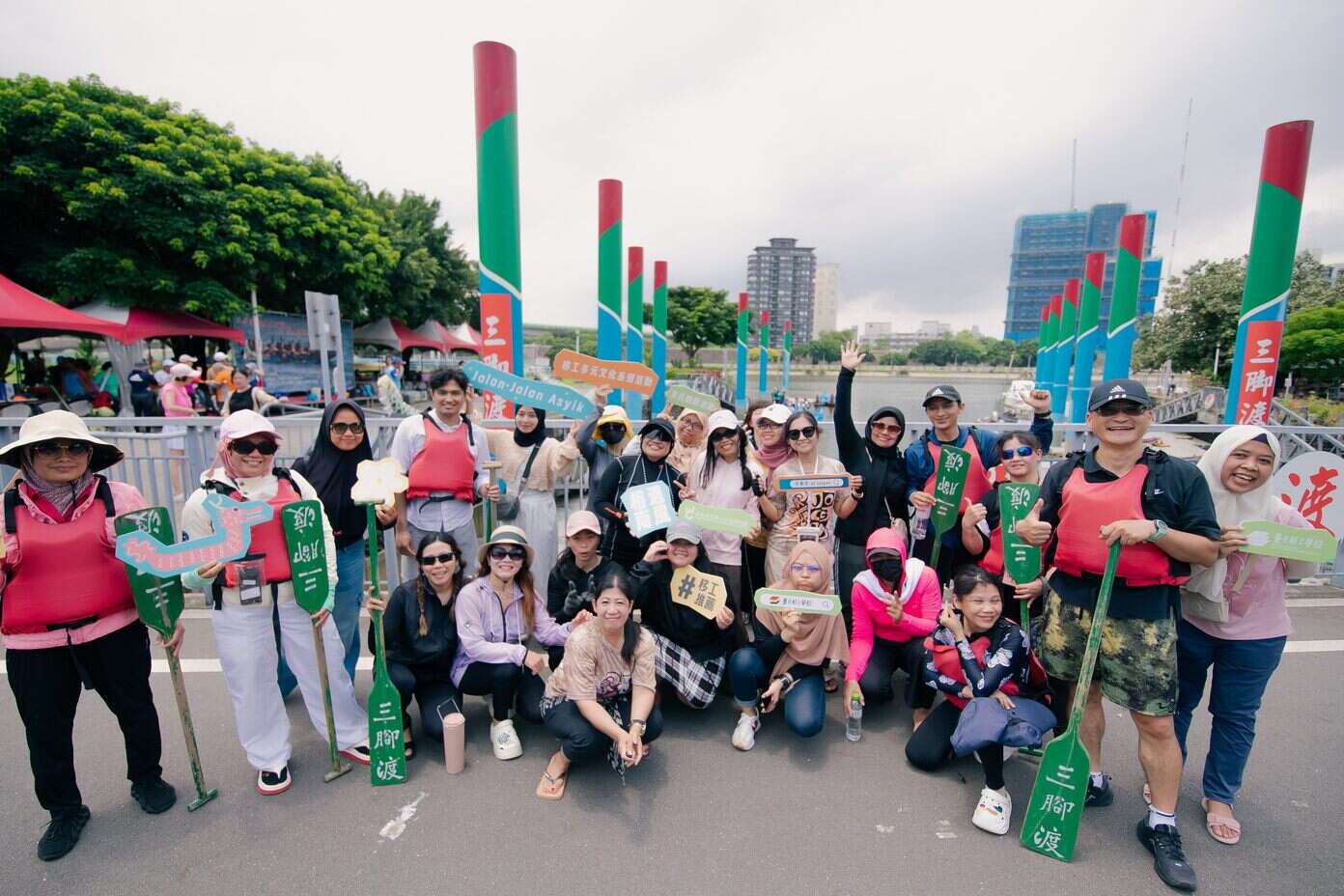 移工们个个开心的划完龙舟在岸上合影(图片来源：台北市政府劳动局)