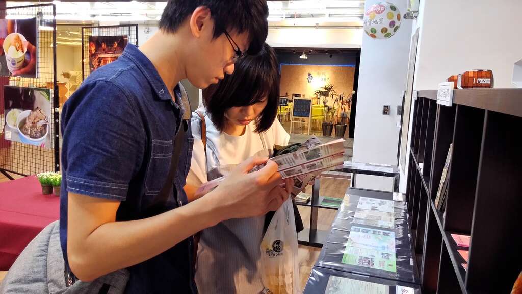 民众於特展现场翻阅文宣品及旅游导览手册