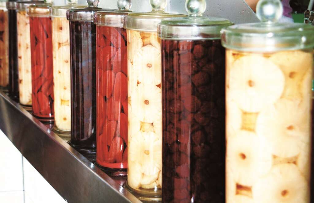 成都杨桃冰店内整排的巨型玻璃罐，浸泡着各种腌渍水果。（摄影／焦桐）