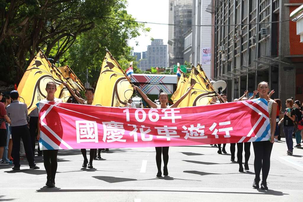 國慶花車遊行隊伍在台北樂府旗隊鼓隊澎湃的鼓聲及壯麗的旗舞中浩盪開場
