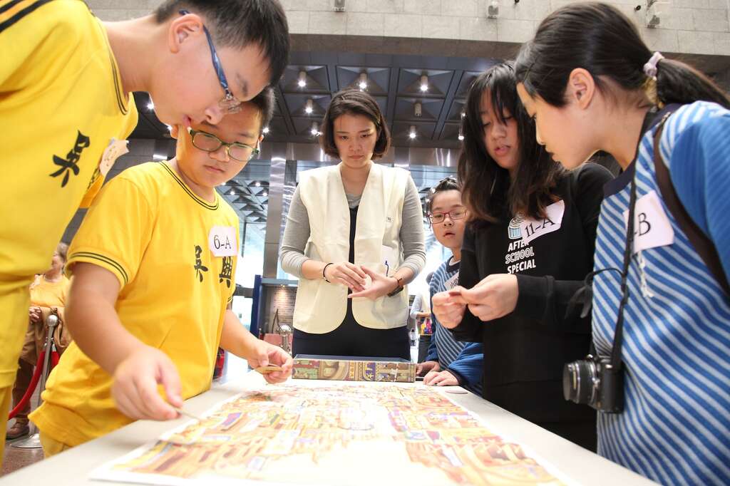 參賽學生們聚精會神，仔細尋找〈南街殷賑〉畫布中的招牌、建築、人物等位置。